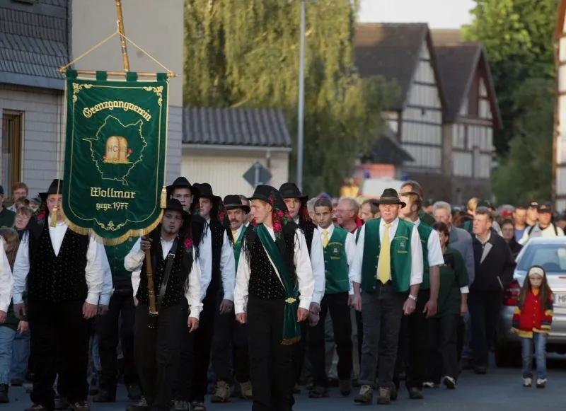 Der Grenzgangverein mit der Vereinsfahne im Ort